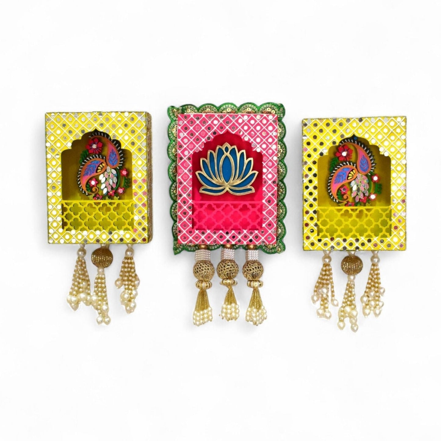 Three wall hangings of pink and yellow with decorative mirrors, beads and pearls tassels on a white background