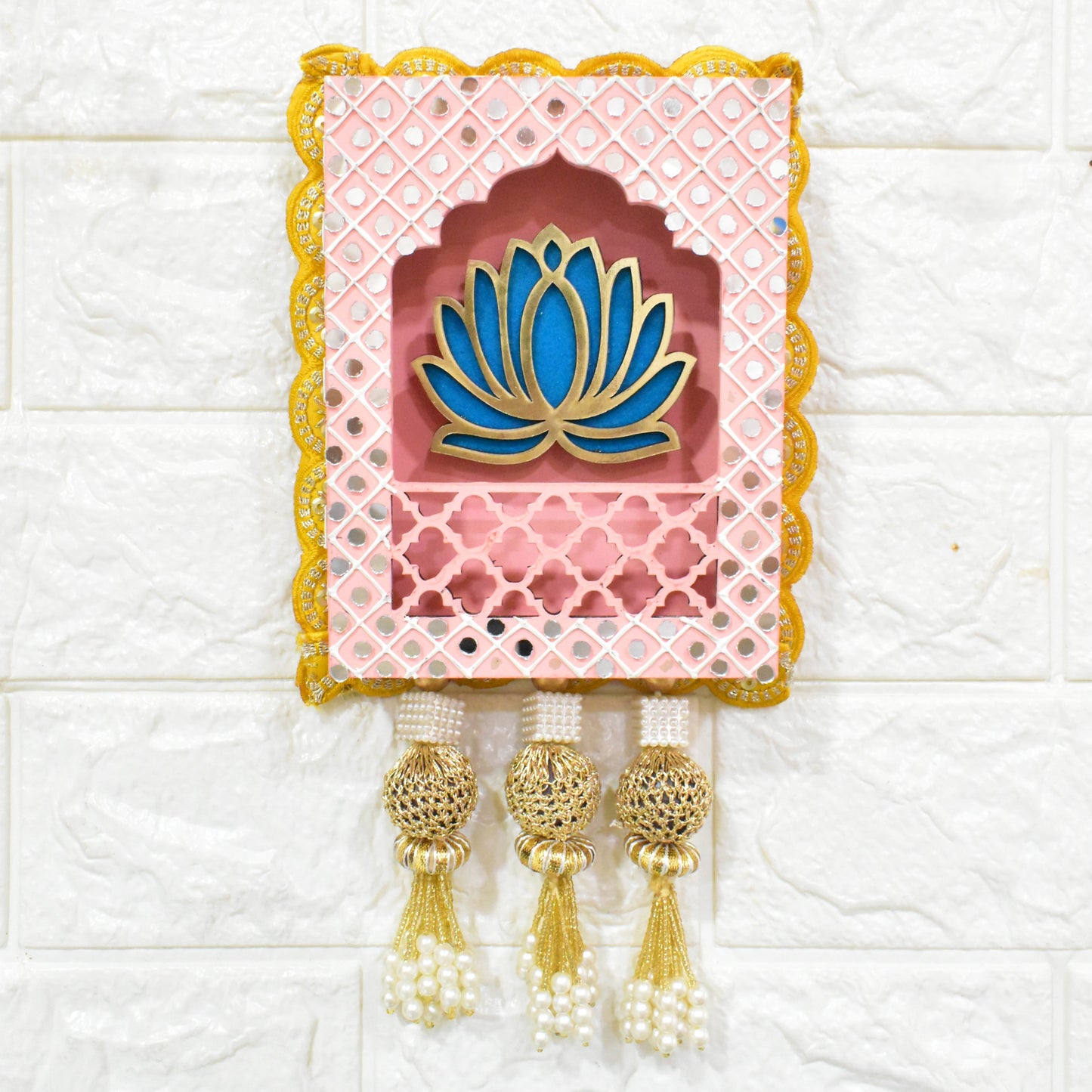Light Pink Indian jharokha wall hangings with lotus motifs, decorative patterns, and tassels, displayed against a light background.