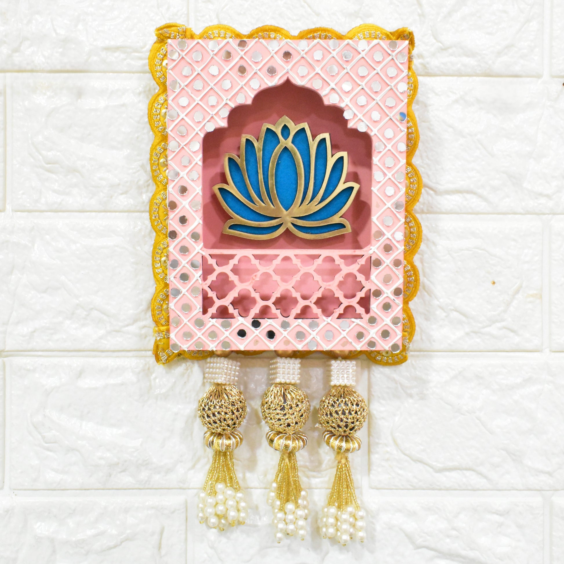 Light Pink Indian jharokha wall hangings with lotus motifs, decorative patterns, and tassels, displayed against a light background.