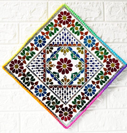 Decorative square tile with colorful floral pattern on a white tiled background