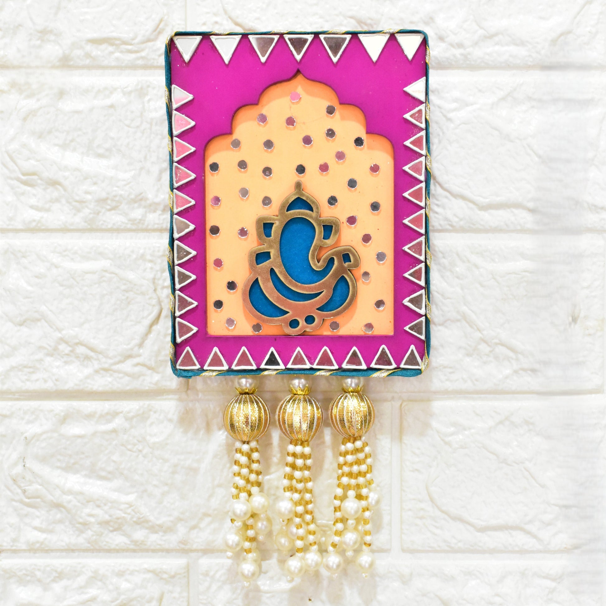 Decorative wall hanging Jharokha with Ganesha design on a pink & orange background with mirrors, pearls beads.