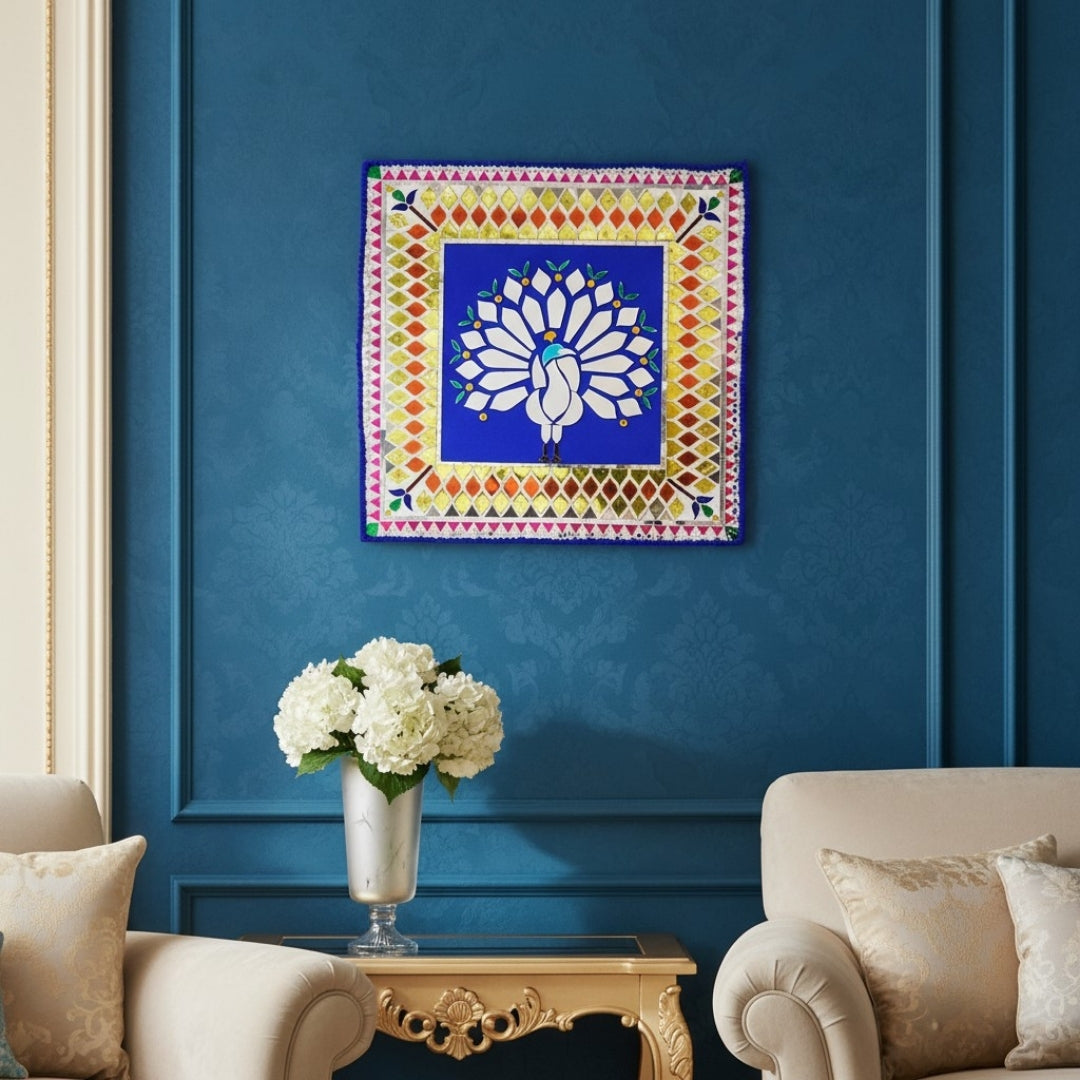 Decorative mirror mosaic wall art with a peacock design on a blue wall above a white sofa and coffee table.
