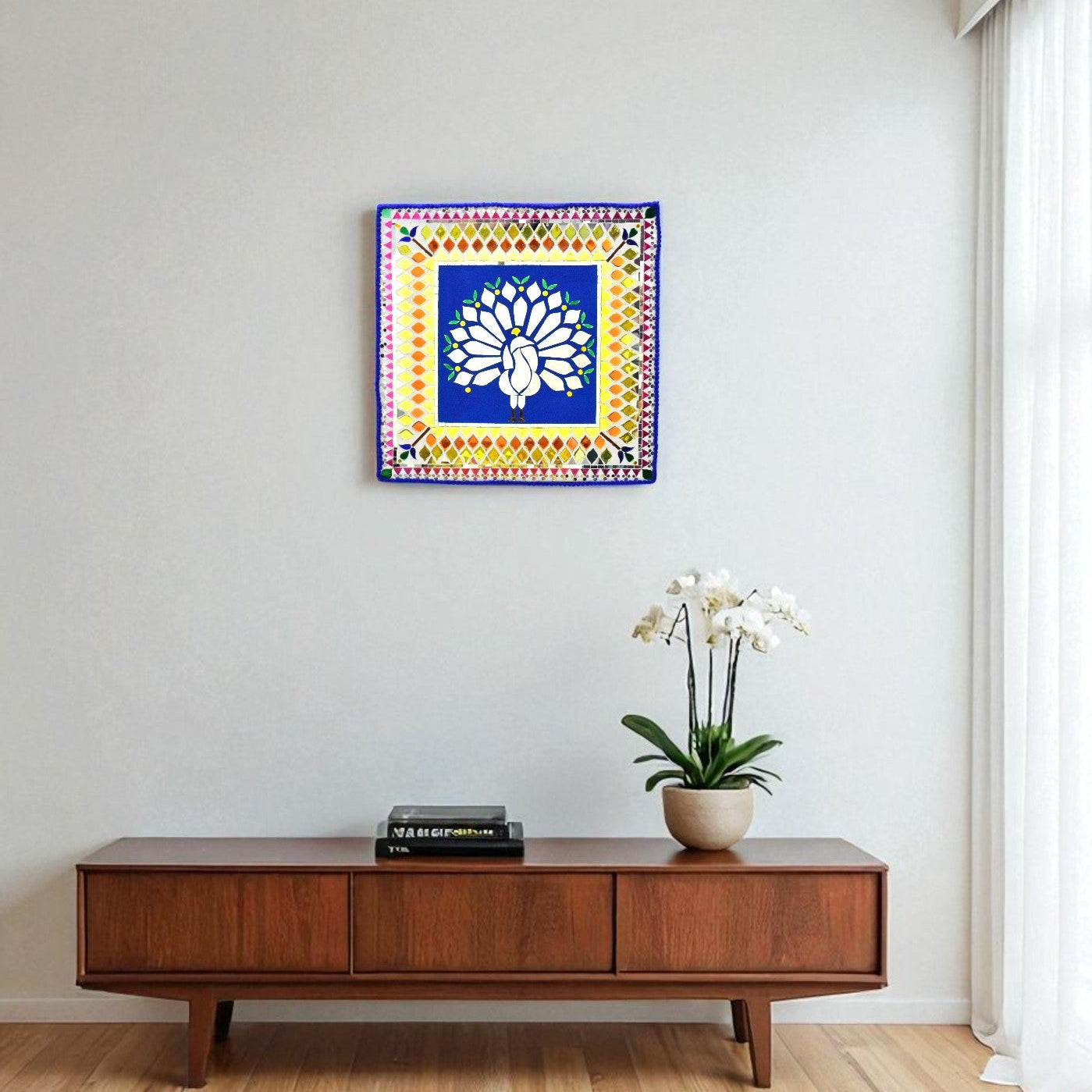 Decorative peacock mirror mosaic wall art above a wooden console table with a plant and books.