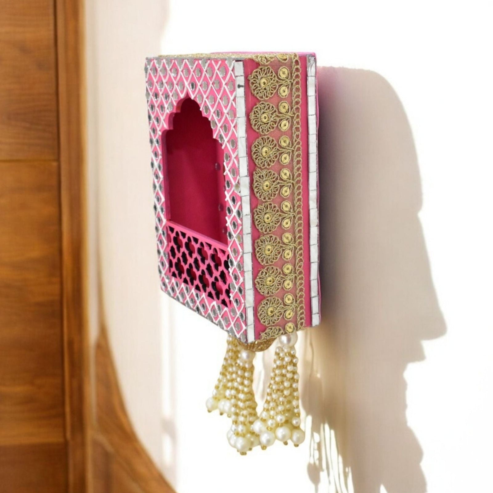 Decorative pink and gold wall hanging with intricate patterns 