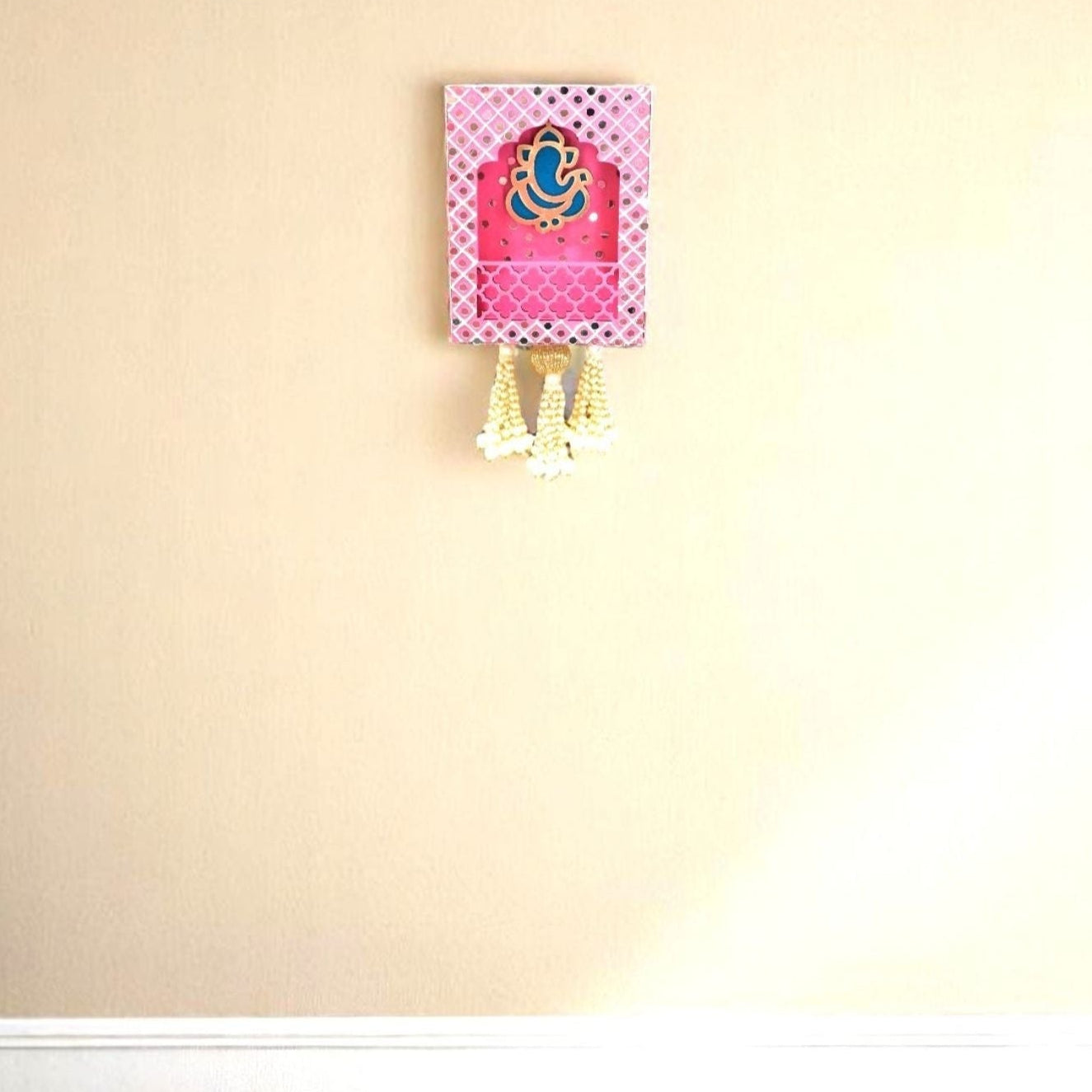 Blue Ganpati decorative wall art on a plain beige wall