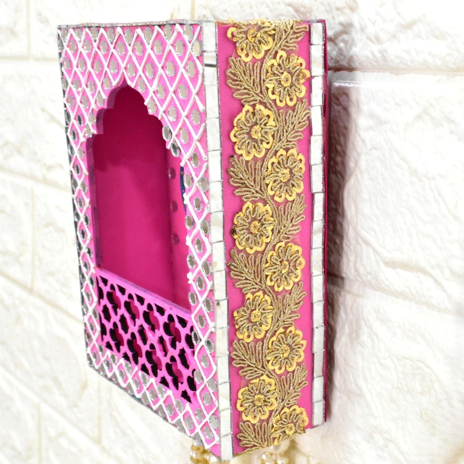 Gold Lace on Pink Wall Jharokha with peacock design and mirrors on a white textured wall.
