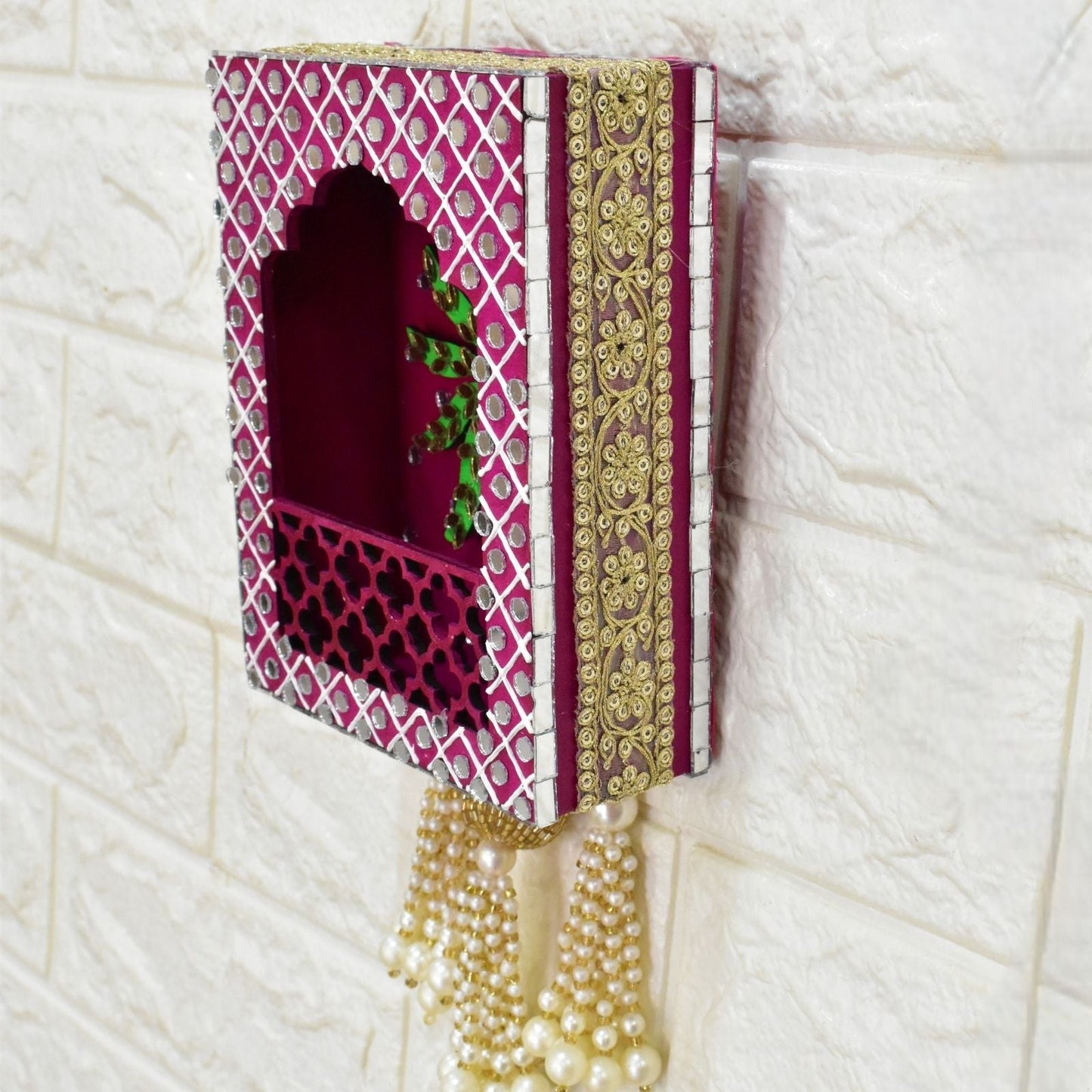 Lace decorative wall hanging with a tree design on a pink background, featuring tassels.