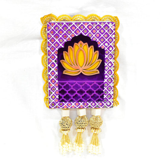 A handmade Lotus Jharokha Wall Hanging with a purple background, yellow lotus flower, and decorative elements including tassels.