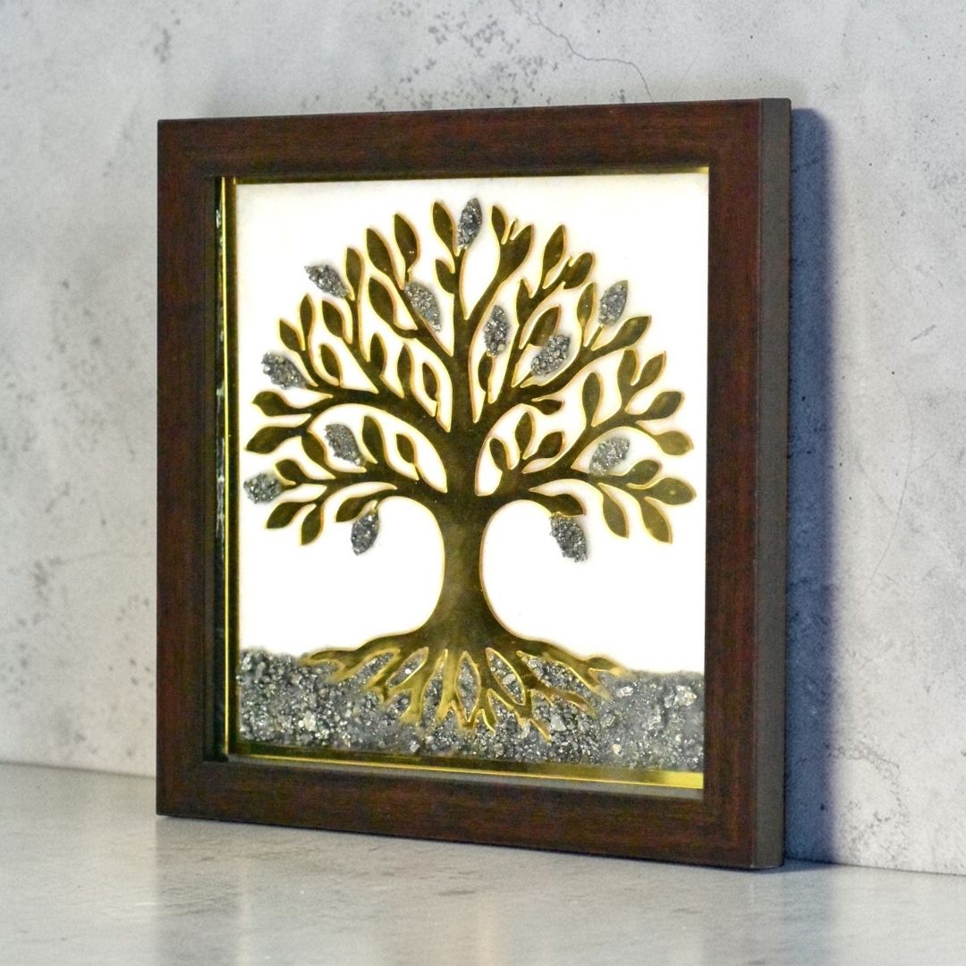 Side angle of a white and gold pyrite tree design on a white resin background, framed in brown.