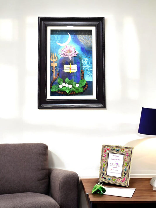 Framed Shivling artwork on a wall above a sofa with a lamp and decorative item on a table.