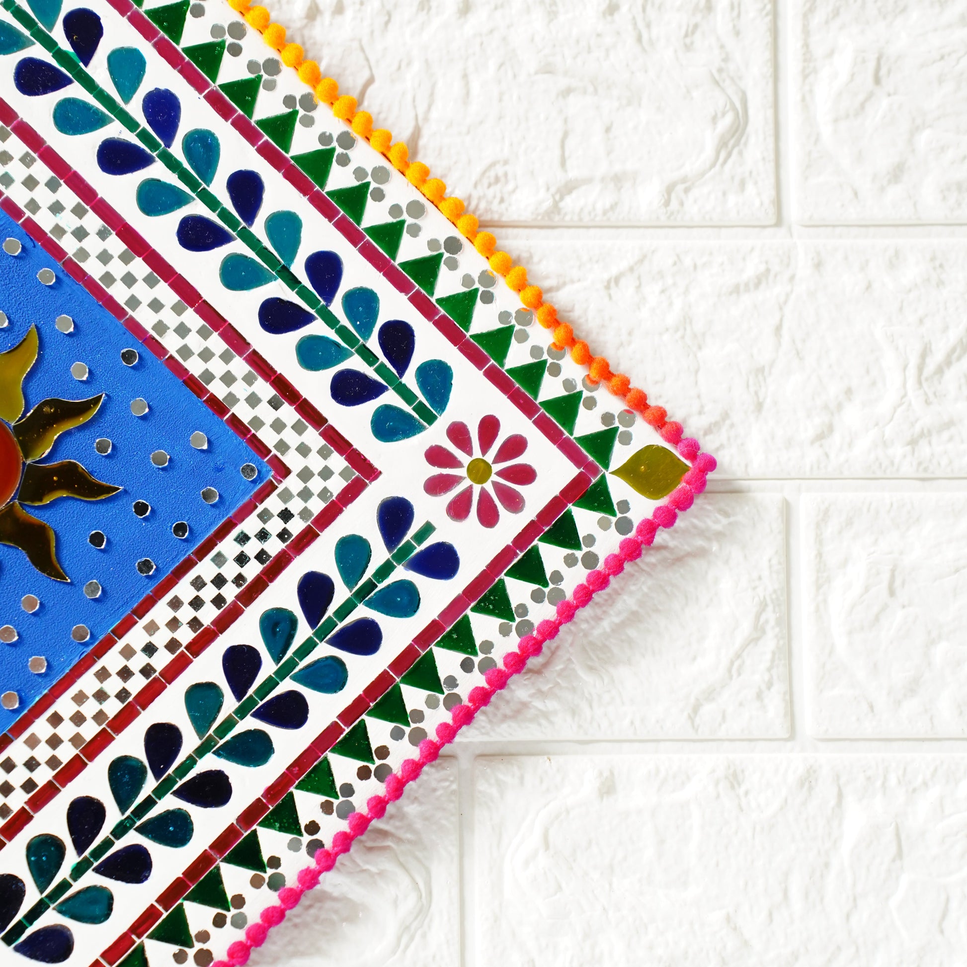Colorful decorative wall art with floral pattern border on a white tiled background