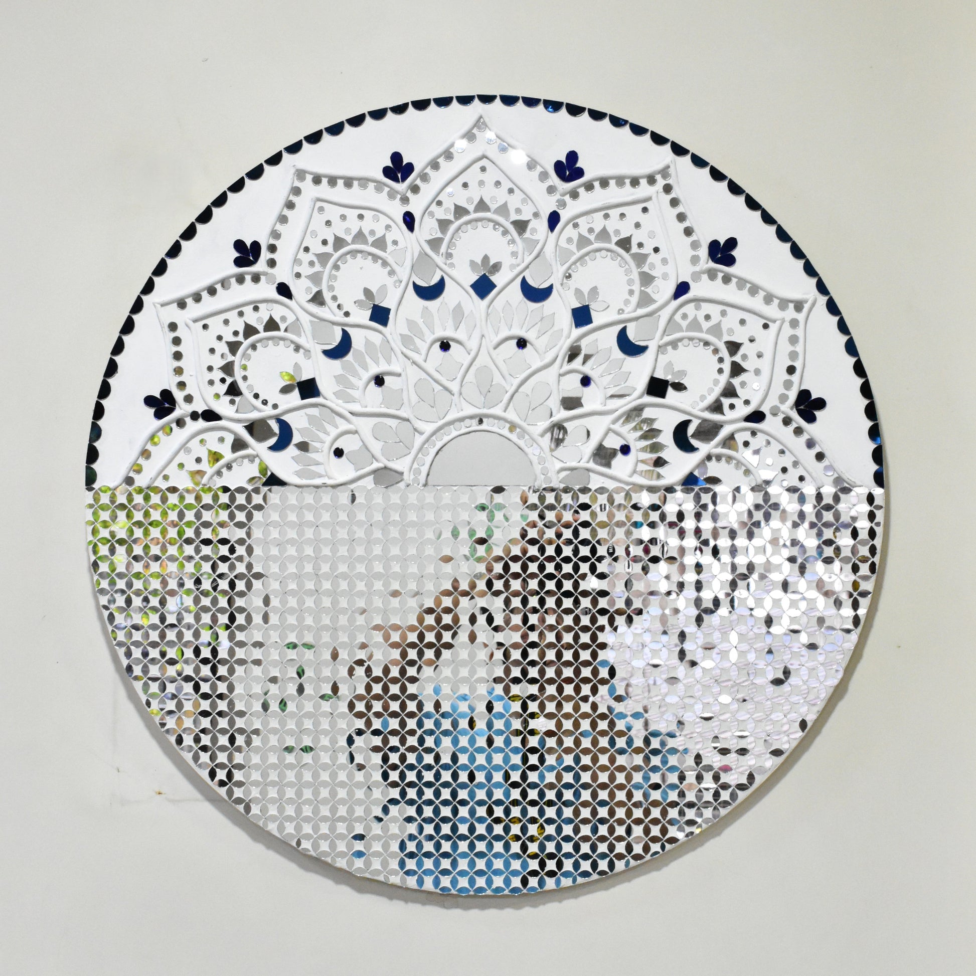 Circular mandala mirror mosaic art piece with intricate patterns on a plain background
