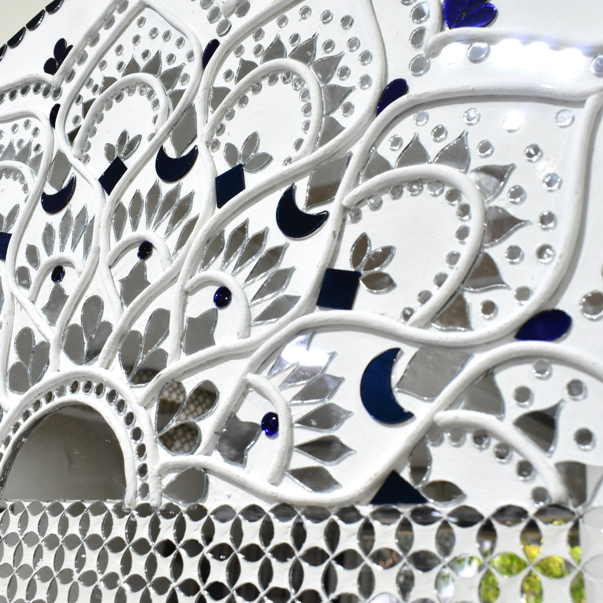 Close up of White Mandala mirror mosaic wall art with intricate patterns and shapes on a white background