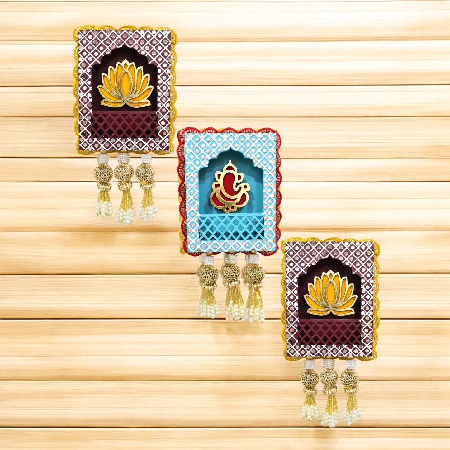 A set of three handcrafted wall hangings featuring Lord Ganesha with a lotus flower design, in blue, red, and gold colors, with decorative elements.